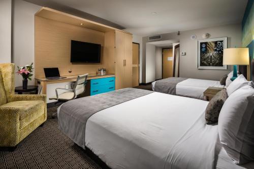 拉斯维加斯Downtown Grand Hotel & Casino的酒店客房配有两张床和一张带笔记本电脑的书桌