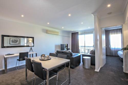 阿德莱德Adelaide Dress Circle Apartments - Archer Street的客厅配有沙发和桌子