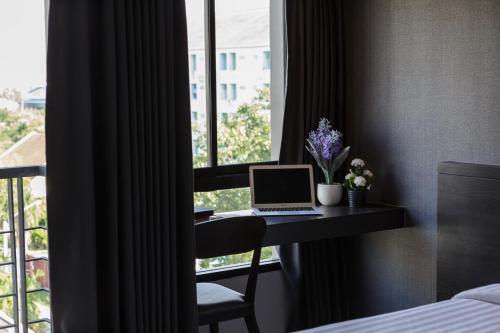 北榄@S115酒店的客房设有一张带笔记本电脑和窗户的书桌。