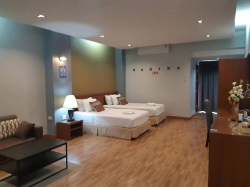 洛坤府拉蒂纳公寓酒店的酒店客房,设有两张床和一张沙发