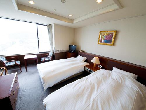 鸣门市凯格苏火影忍者日式旅馆的酒店客房设有两张床和窗户。