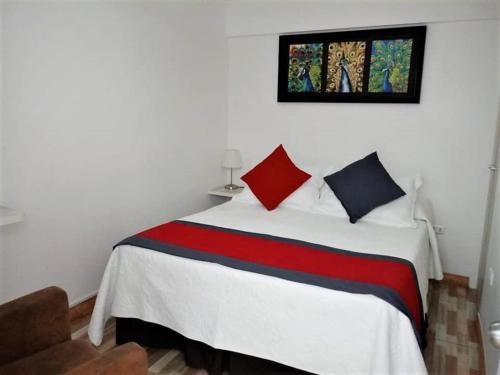 阿里卡Guest Home Valto & Ziron的一间卧室配有白色的床和红色和蓝色枕头