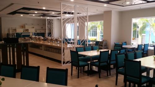 古晋港景酒店的一间带桌椅的餐厅和一间酒吧