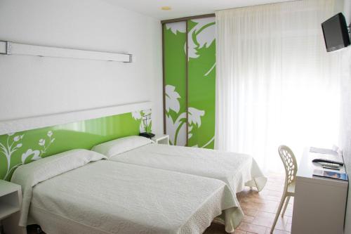 圣何塞Pension Agadir的卧室配有白色的床和绿色的墙壁