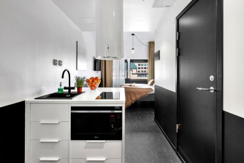 奥斯陆奥斯陆福诺公寓式酒店的厨房配有白色橱柜和黑色门