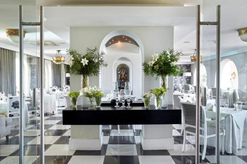 赫曼努斯海洋赫曼努斯酒店的用餐室,配有鲜花桌