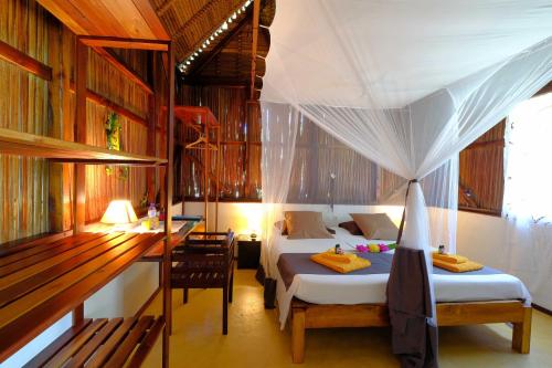Nosy KombaCoco Komba Lodge的一间卧室配有两张床、一张桌子和一张桌子