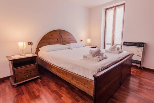 瓦伦纳Il mulino的一间卧室配有一张大床和木制床头板