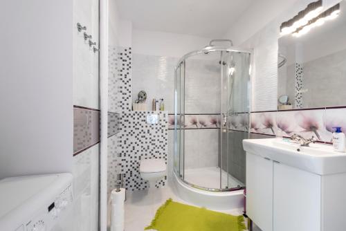 华沙Przytulny Apartament przy Teatrze Wielkim的带淋浴和盥洗盆的白色浴室