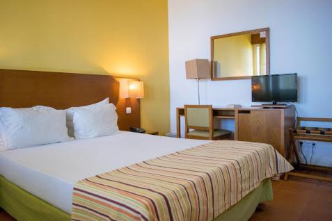 圣菲利佩Bamboo Xaguate Hotel的酒店客房设有一张大床和一张书桌。