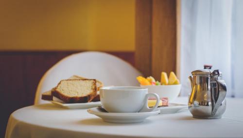 奥瓦列Gran Hotel Ovalle的桌子,上面放着咖啡和一盘面包