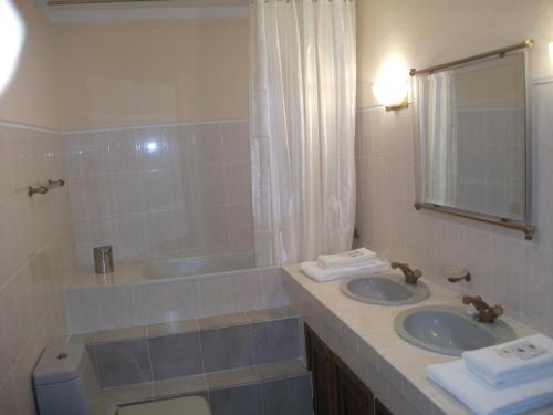萨布罗萨Casa Deus的一间带两个盥洗盆、浴缸和卫生间的浴室