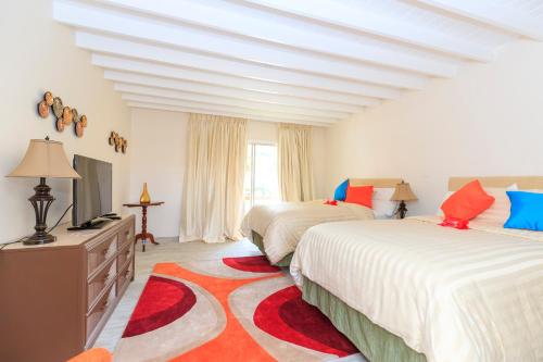 金斯敦森特所瑞斯比奇酒店的一间卧室配有两张床和电视。