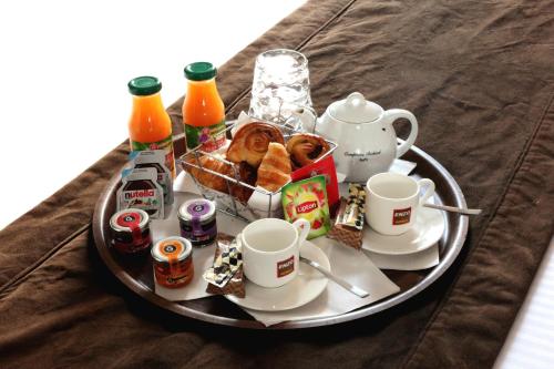 坎尼斯伊克鲁斯Enzo Hotels Cannes-Écluse by Kyriad Direct的桌上的早餐食品和饮料托盘