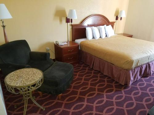 埃文斯维尔埃文斯维尔东美洲最佳价值旅馆的配有一张床和一把椅子的酒店客房