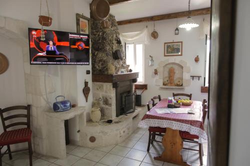 马蒂纳塔Il Casale Delle Principesse的客厅配有桌子和石头壁炉