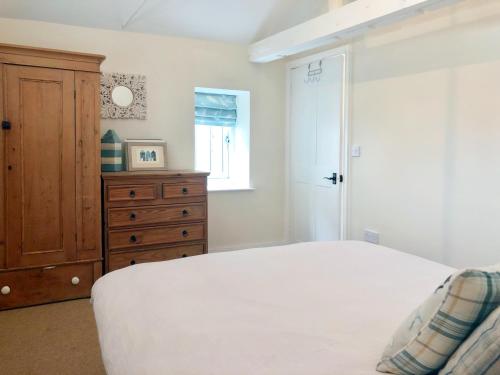 East RudhamBakers Court的卧室配有白色的床和木制梳妆台。