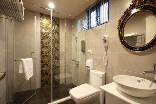 嘉义市來嘉小棧的一间带卫生间、水槽和镜子的浴室