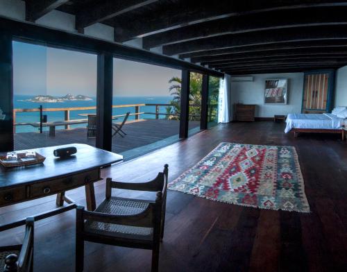 里约热内卢CLIFFSIDE - Boutique Hotel & Spa的客厅配有桌子,享有海景