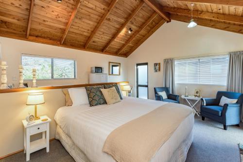 OpuaHarbour View Cottage Bay of Islands的一间卧室配有一张床、一张桌子和一把椅子