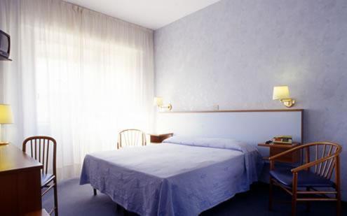 塞勒里古里维埃拉酒店的一间卧室配有一张床、两把椅子和一个窗户