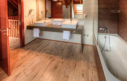 萨连特加列戈特雷斯醌公寓酒店的浴室配有两个盥洗盆和浴缸。