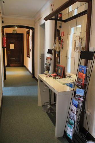 毕尔巴鄂马诺利高级旅馆的一间设有书桌的房间和一个带门的走廊