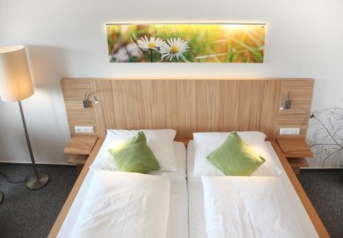 富尔达盖斯索夫阿尔特斯赌场酒店的一间卧室配有带白色床单和绿色枕头的床。