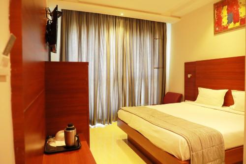 钦奈Avenue Hotel的酒店客房设有床和窗户。