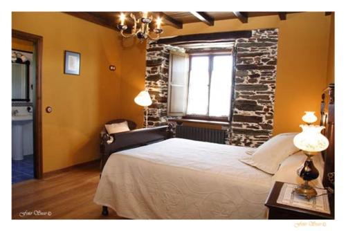 里瓦德奥Casa Rural Vila Pomar的一间卧室设有一张床和砖墙