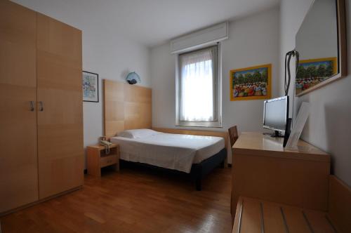 帕多瓦伊赫亚酒店的一间卧室配有一张床、一张书桌和一台电视