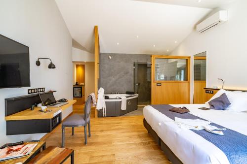 雷岛林滩Hôtel Ile de Ré的一间卧室配有一张床、一张书桌和一个浴缸