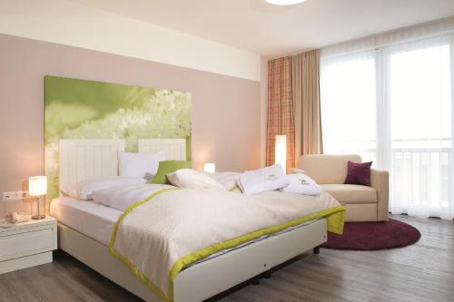 利恩茨霍兰德霍夫酒店的一间卧室配有一张大床和一张沙发