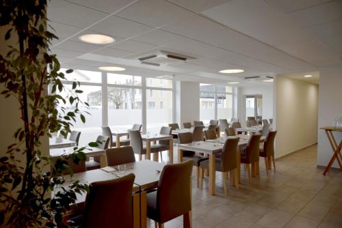 DelmeLogis Restaurant & Hôtel À la 12的用餐室设有桌椅和窗户。