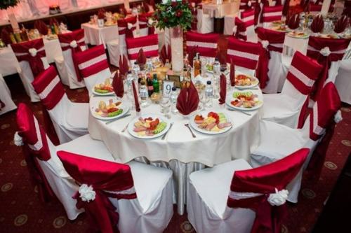 普列文罗斯托夫酒店的一张桌子,上面放着食物盘子和红色及白色的椅子