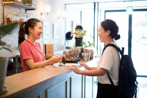 金泽金泽太平洋酒店的两名妇女站在咖啡店柜台