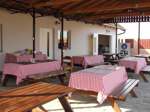 KoviljCoffeecamp-Kovilj的庭院设有红色的白色桌子和长凳