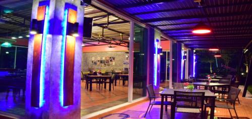 农布努布道度假酒店及餐厅的餐厅设有桌椅和紫色灯