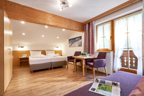 圣安东阿尔贝格兰德豪斯陶兹酒店的酒店客房配有一张床铺和一张桌子。