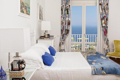 卡普里卡萨玛塔卡普里酒店的一间卧室设有一张床,享有海景