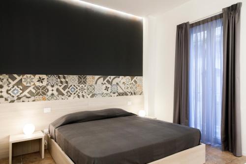 帕拉佐洛阿克雷伊德b&b del Corso的一间卧室设有一张床和一个大窗户