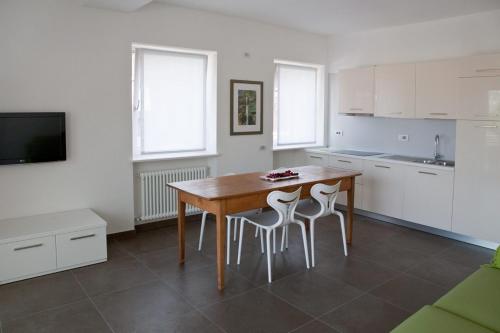 托尔博莱Casa Rosa dei Venti的厨房配有木桌和2张凳子