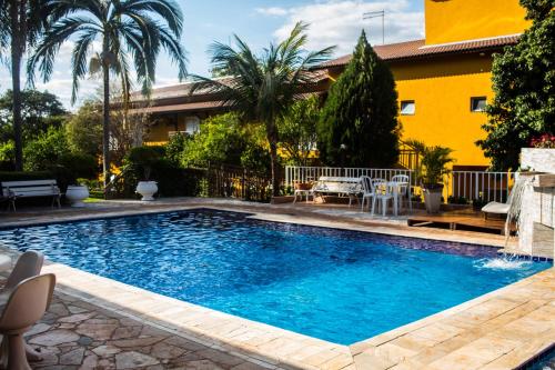 里贝朗普雷托香格里拉旅馆的一座游泳池,位于一个有黄色房子的庭院内