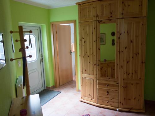 巴特多布兰Ferienwohnung Holunderweg的一间设有绿色墙壁和大型木制橱柜的客房