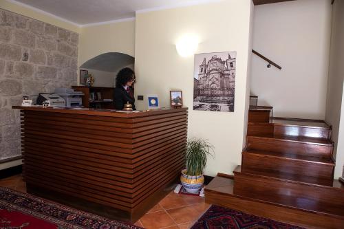 佩特拉利亚索普拉纳Hotel Residenza Petra的坐在桌子上的女人,坐在楼梯间
