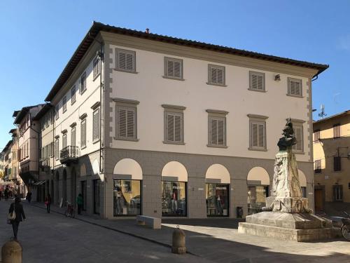 蒙特瓦尔基Palazzo Vasarri - Luxury design suites的一座大建筑,前面有雕像