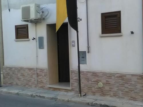 奥里亚Elisea House的白色建筑的敞开门,有黄色的旗帜