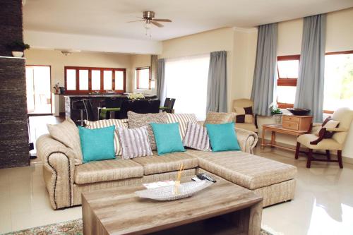 埃祖尔韦尼Green Haven Luxury Apartments的客厅配有沙发和桌子