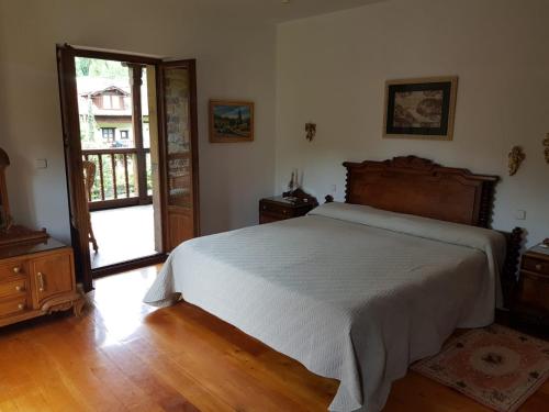 卡马莱尼奥Casa Rural San Pelayo的一间卧室设有一张床和一个开放式门