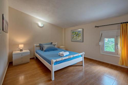 MixórroumaAliki Serenity Cottage的一间卧室设有蓝色的床和窗户。